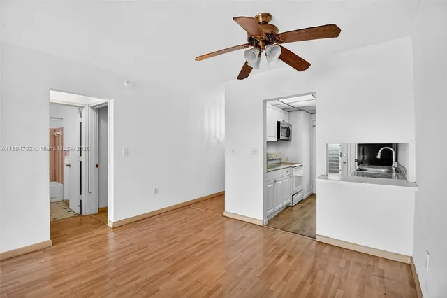 a kitchen with granite countertop a sink stainless steel appliances and white cabinets