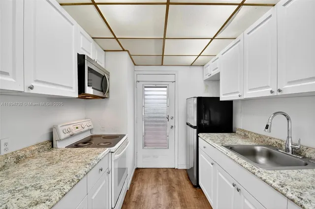 a kitchen with stainless steel appliances granite countertop a sink a stove and cabinets