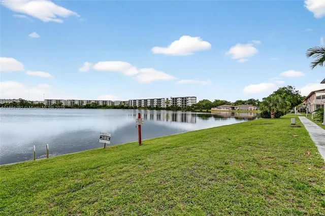 a view of empty room with wooden floor and chandelier