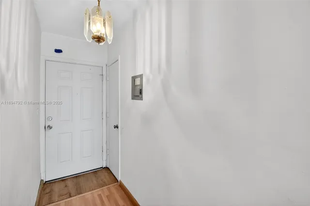 a view of empty room with wooden floor and window