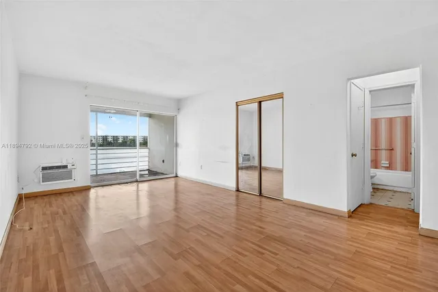 a kitchen with white cabinets and wooden floor