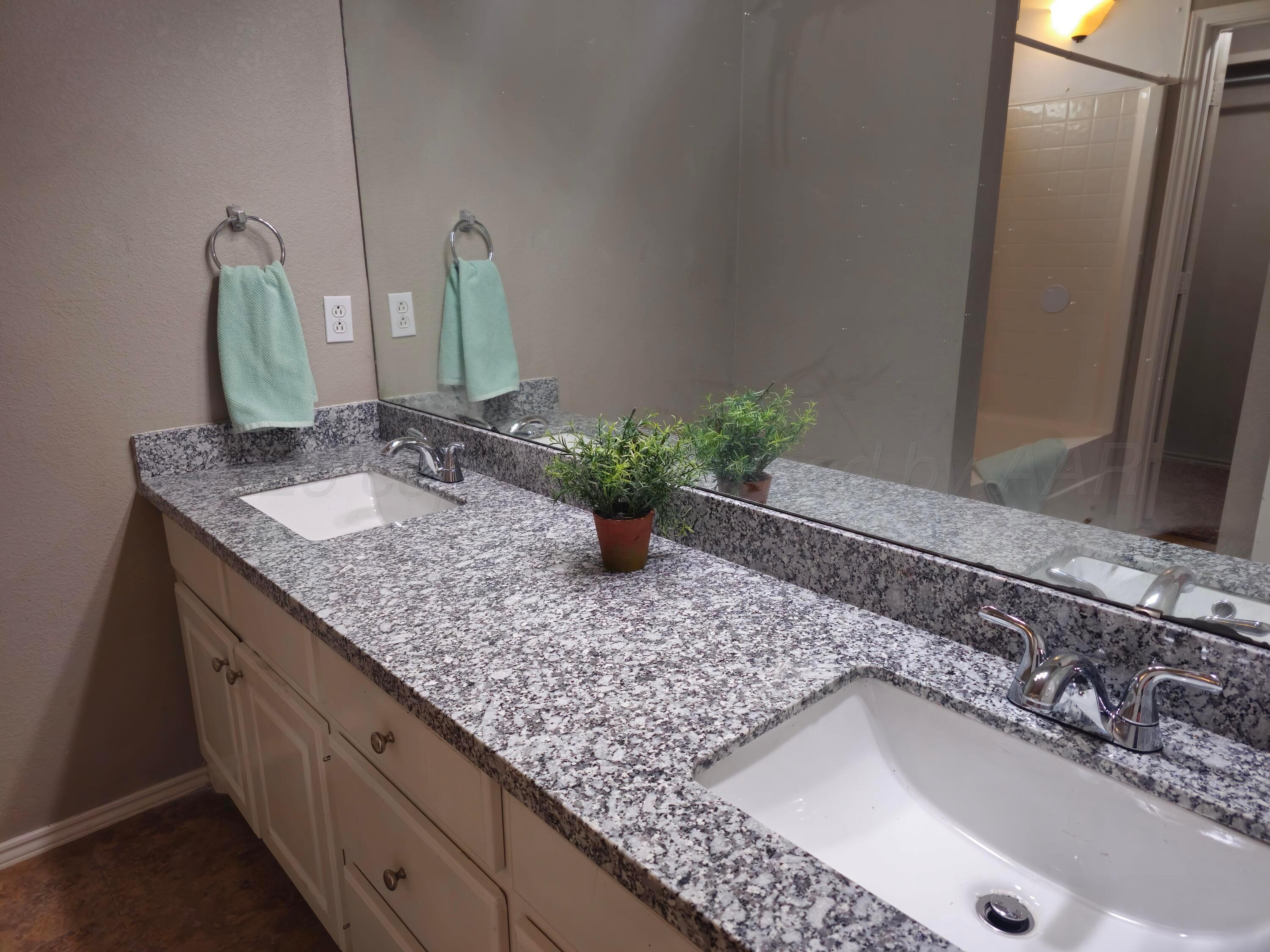 1918 75th Street Lubbock, TX 79423 - Photo 12 of 23 a bathroom with a granite countertop sink and a mirror