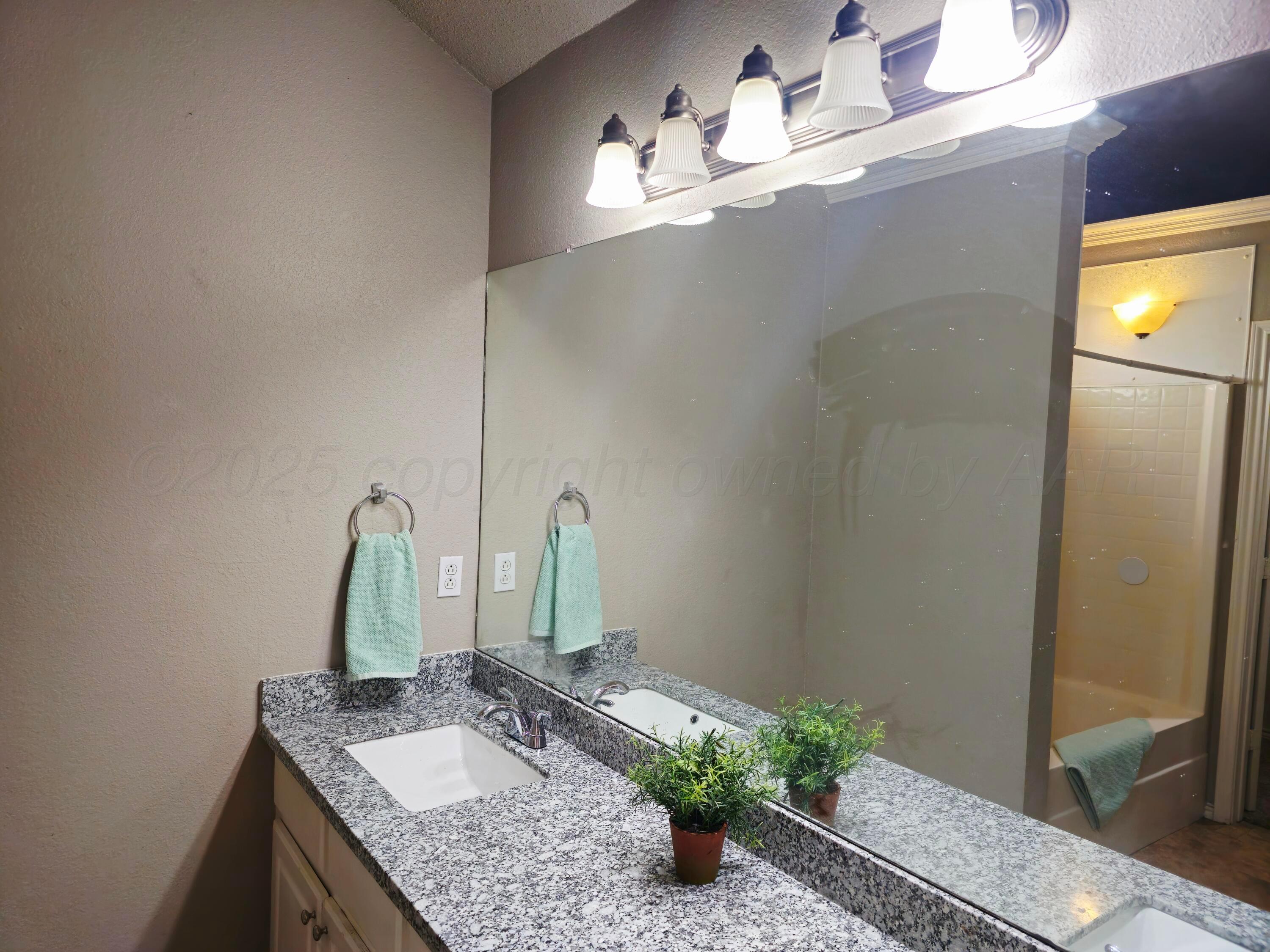 1918 75th Street Lubbock, TX 79423 - Photo 14 of 23 a bathroom with a granite countertop sink and a mirror