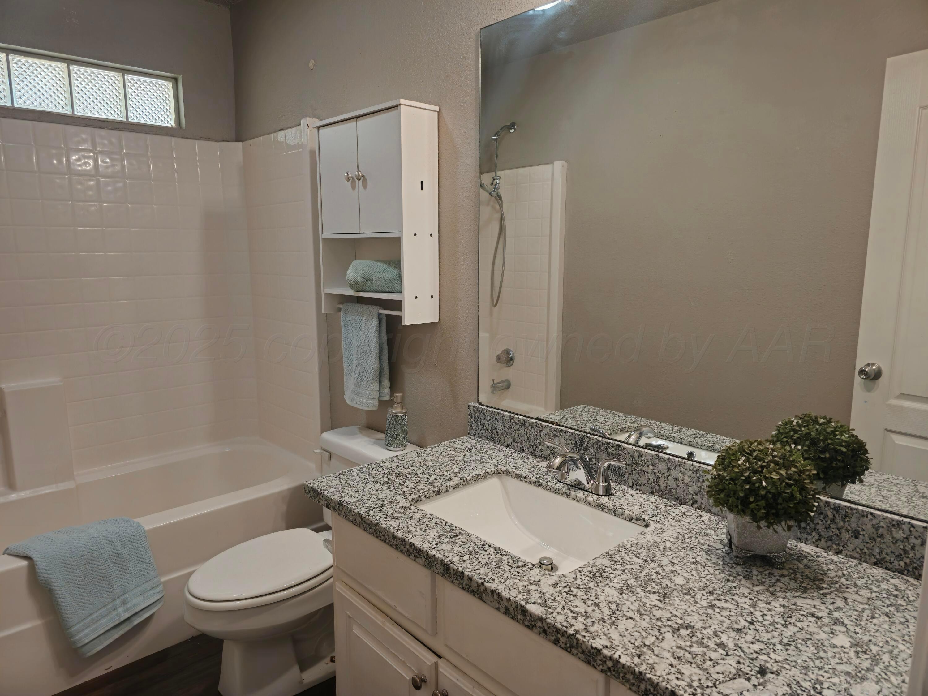 1918 75th Street Lubbock, TX 79423 - Photo 16 of 23 a bathroom with a granite countertop sink toilet and shower