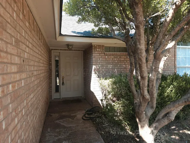 a yellow house with trees in front of it