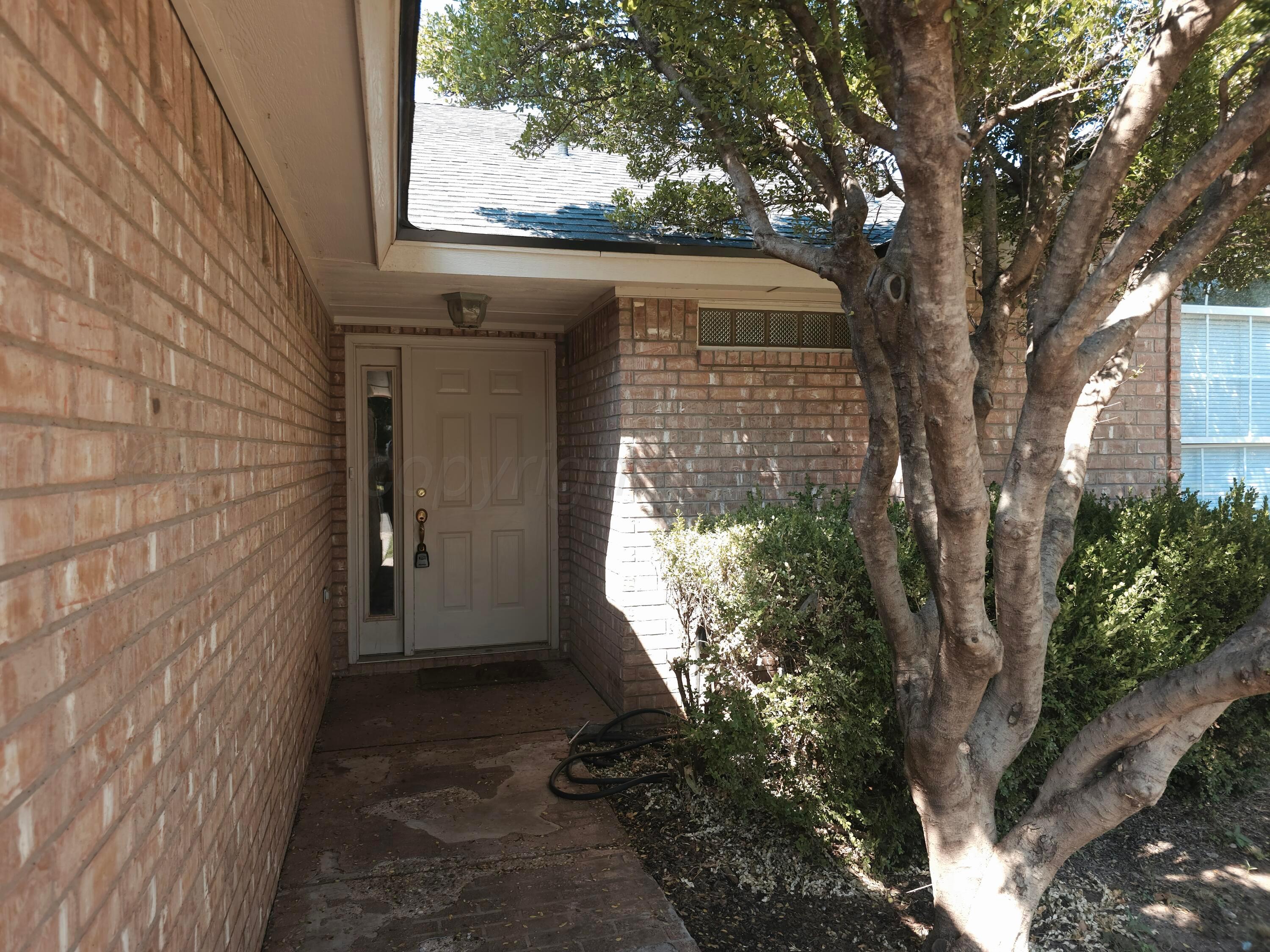 1918 75th Street Lubbock, TX 79423 - Photo 22 of 23 a yellow house with trees in front of it