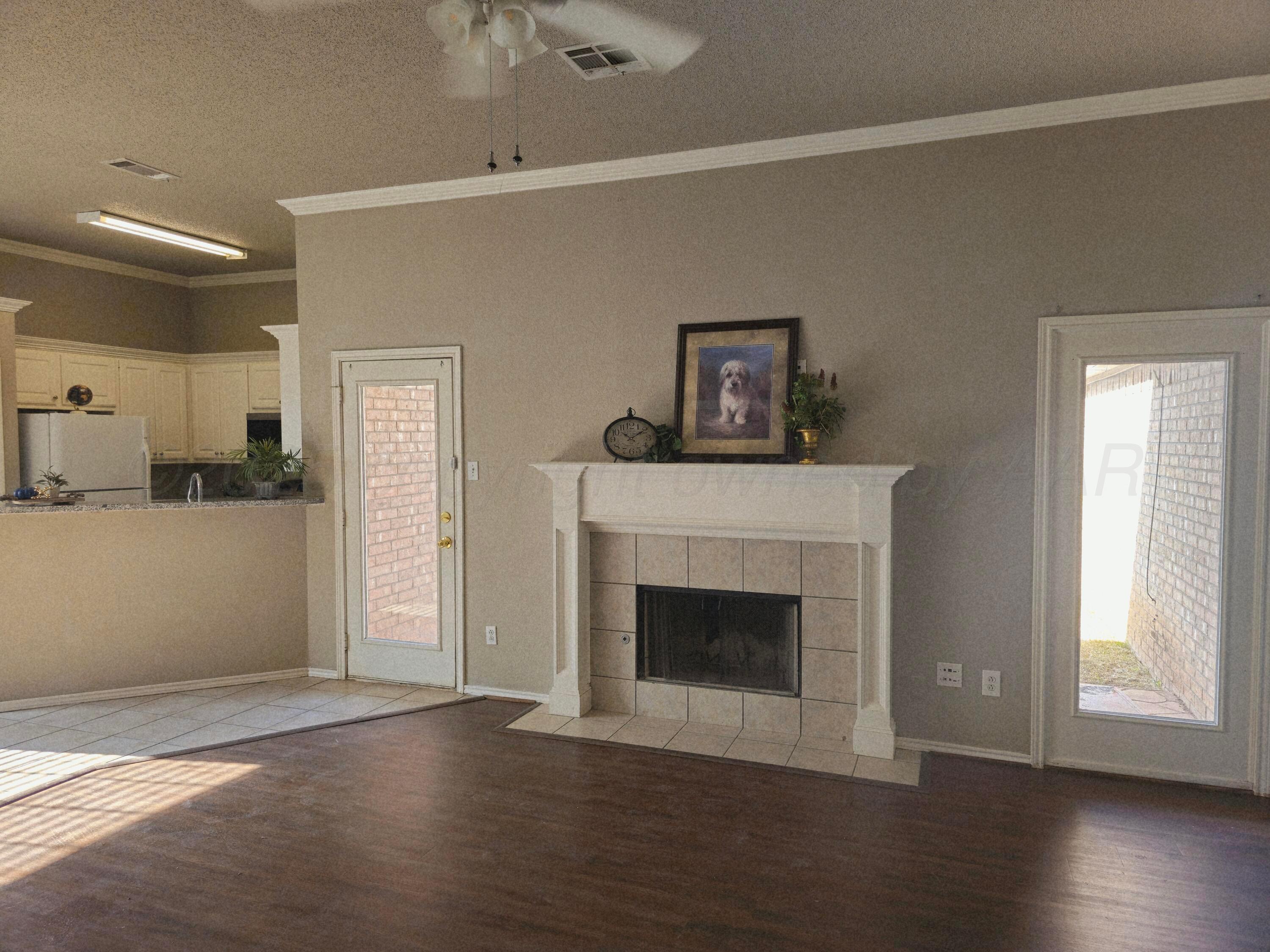 1918 75th Street Lubbock, TX 79423 - Photo 3 of 23 a living room with a fireplace and wooden floor