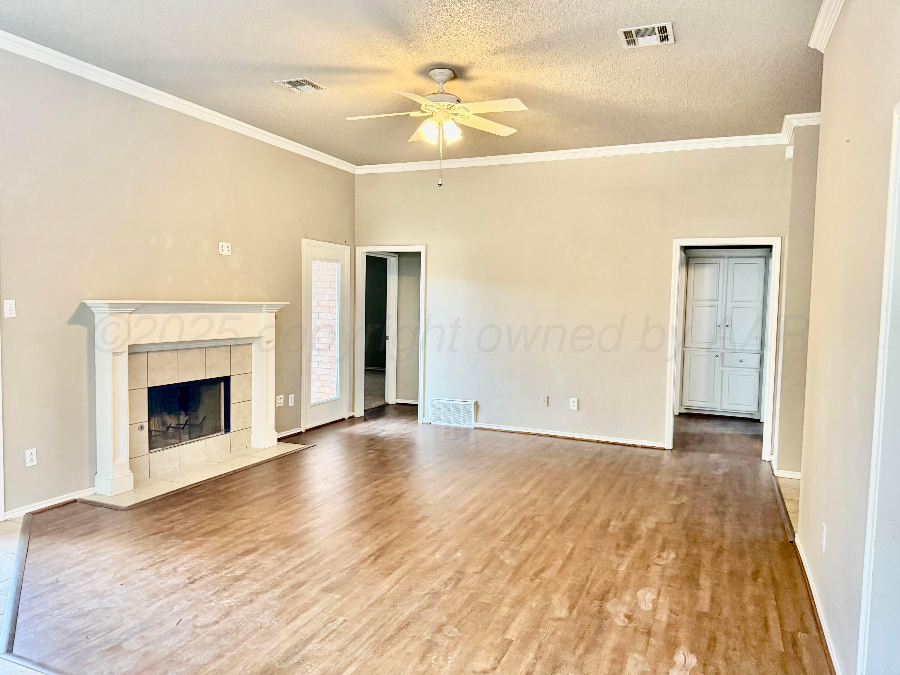 1918 75th Street Lubbock, TX 79423 - Photo 4 of 23 a view of a livingroom with a fireplace and a ceiling fan