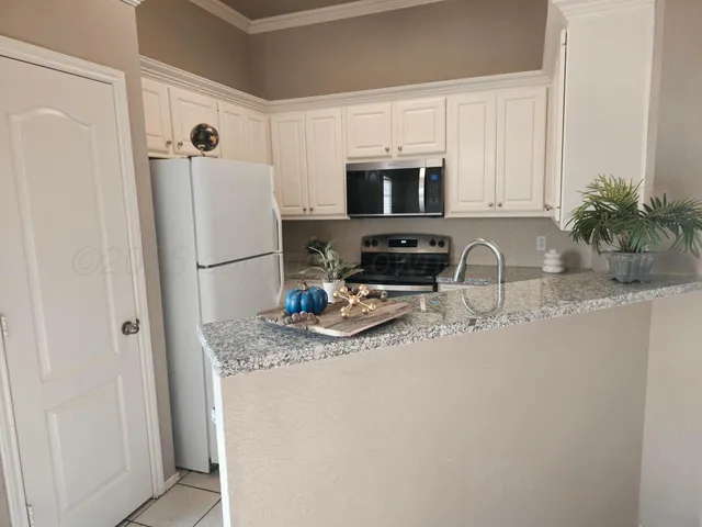 a kitchen with stainless steel appliances granite countertop a refrigerator a stove a sink a microwave and cabinets