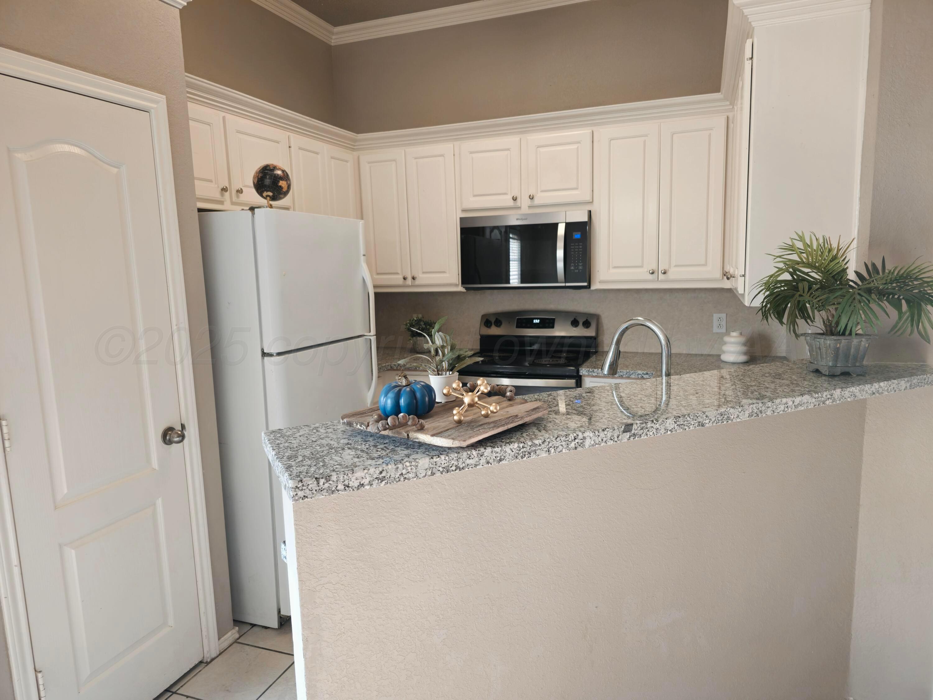 1918 75th Street Lubbock, TX 79423 - Photo 6 of 23 a kitchen with stainless steel appliances granite countertop a refrigerator a stove a sink a microwave and cabinets