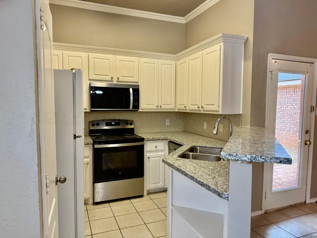 a kitchen with granite countertop a stove and a refrigerator