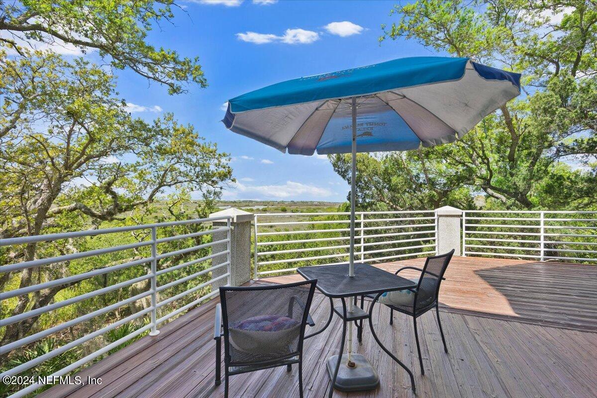 3419 Lands End Drive St. Augustine, FL 32084 - Photo 13 of 59 a view of a patio with table and chairs under an umbrella with wooden floor