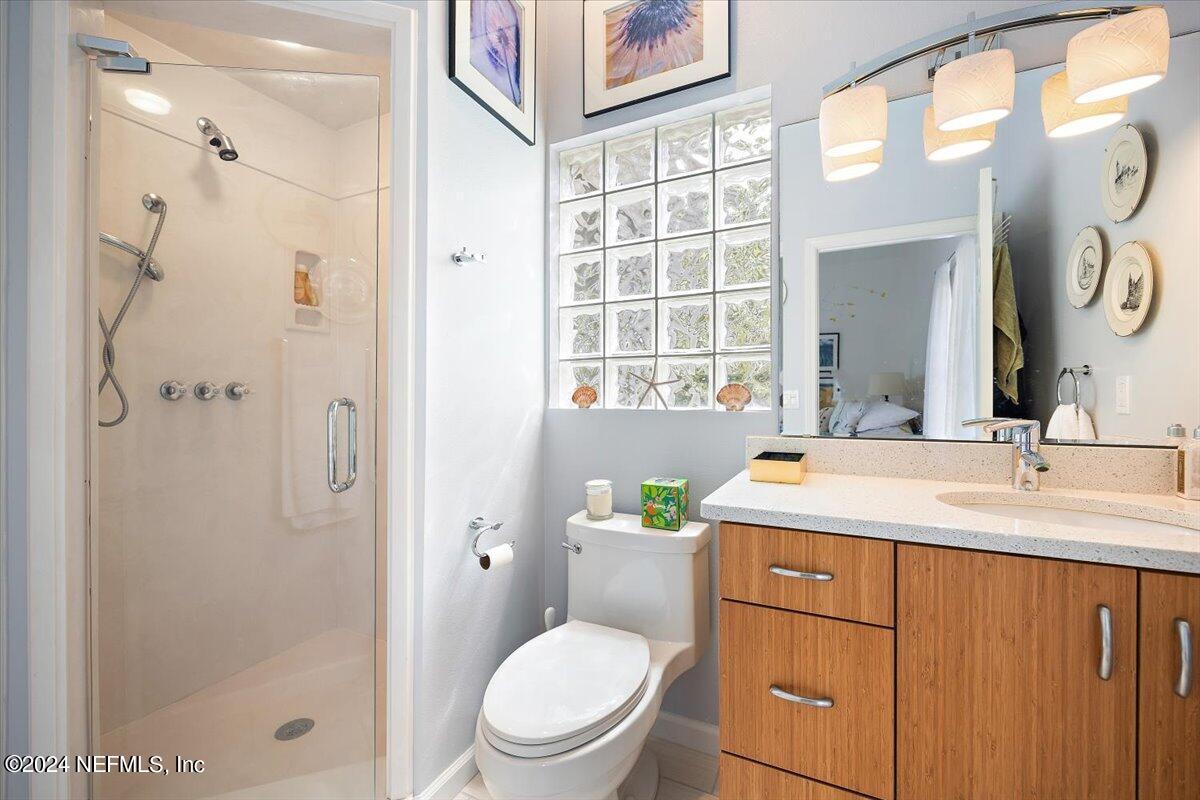 3419 Lands End Drive St. Augustine, FL 32084 - Photo 24 of 59 a bathroom with a granite countertop sink toilet a mirror and shower