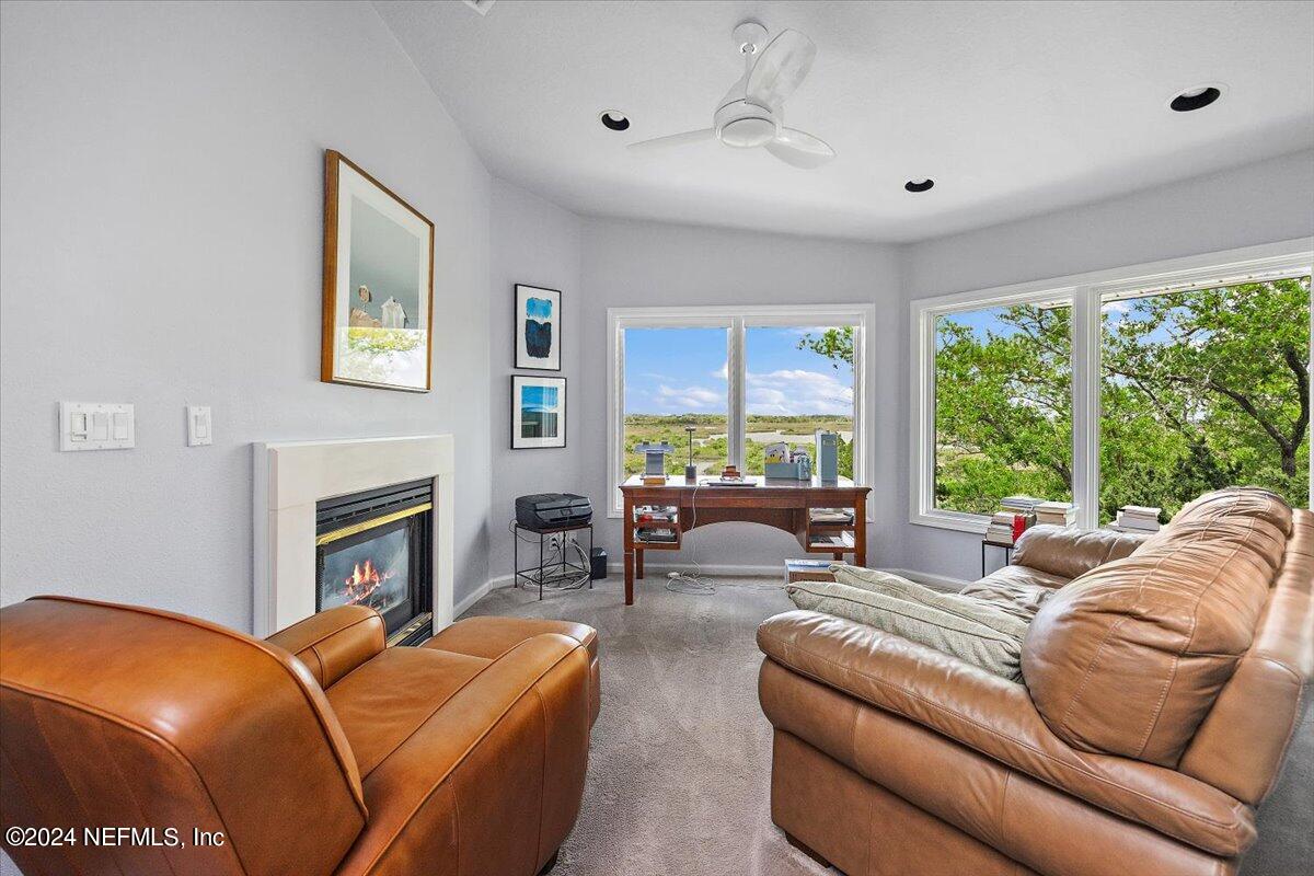 3419 Lands End Drive St. Augustine, FL 32084 - Photo 27 of 59 a living room with furniture a fireplace and a large window
