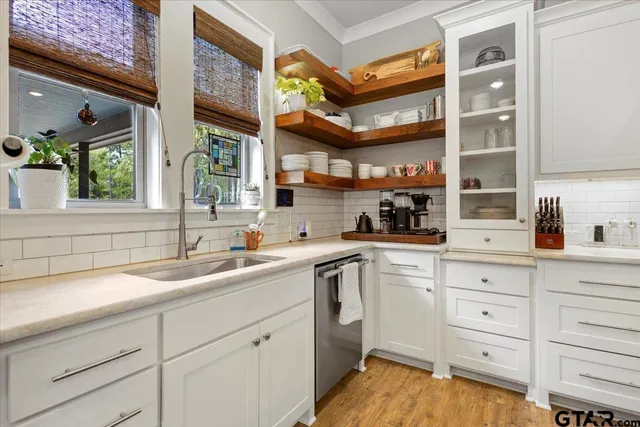 a kitchen with cabinets stainless steel appliances a sink and a window