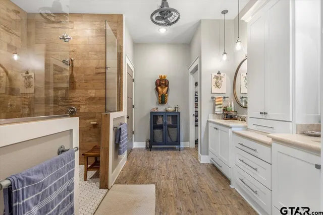 a spacious bathroom with a double vanity sink a mirror and a shower
