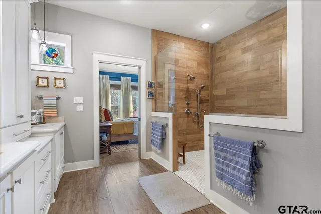 a spacious bathroom with a glass door shower and a sink