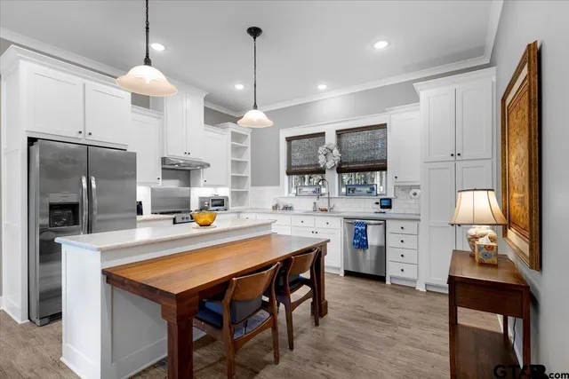 a kitchen with stainless steel appliances a stove center island refrigerator and cabinets