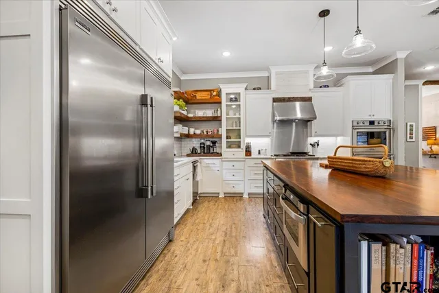 a kitchen with kitchen island a counter top space a sink stainless steel appliances and cabinets