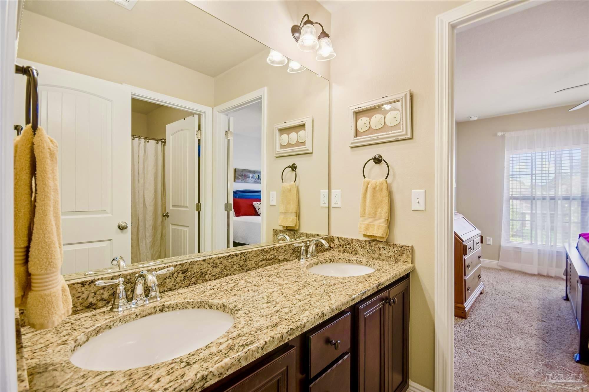 745 Farmington Road Pensacola, FL 32504 - Photo 20 of 25 a bathroom with a granite countertop sink a mirror a vanity and shower