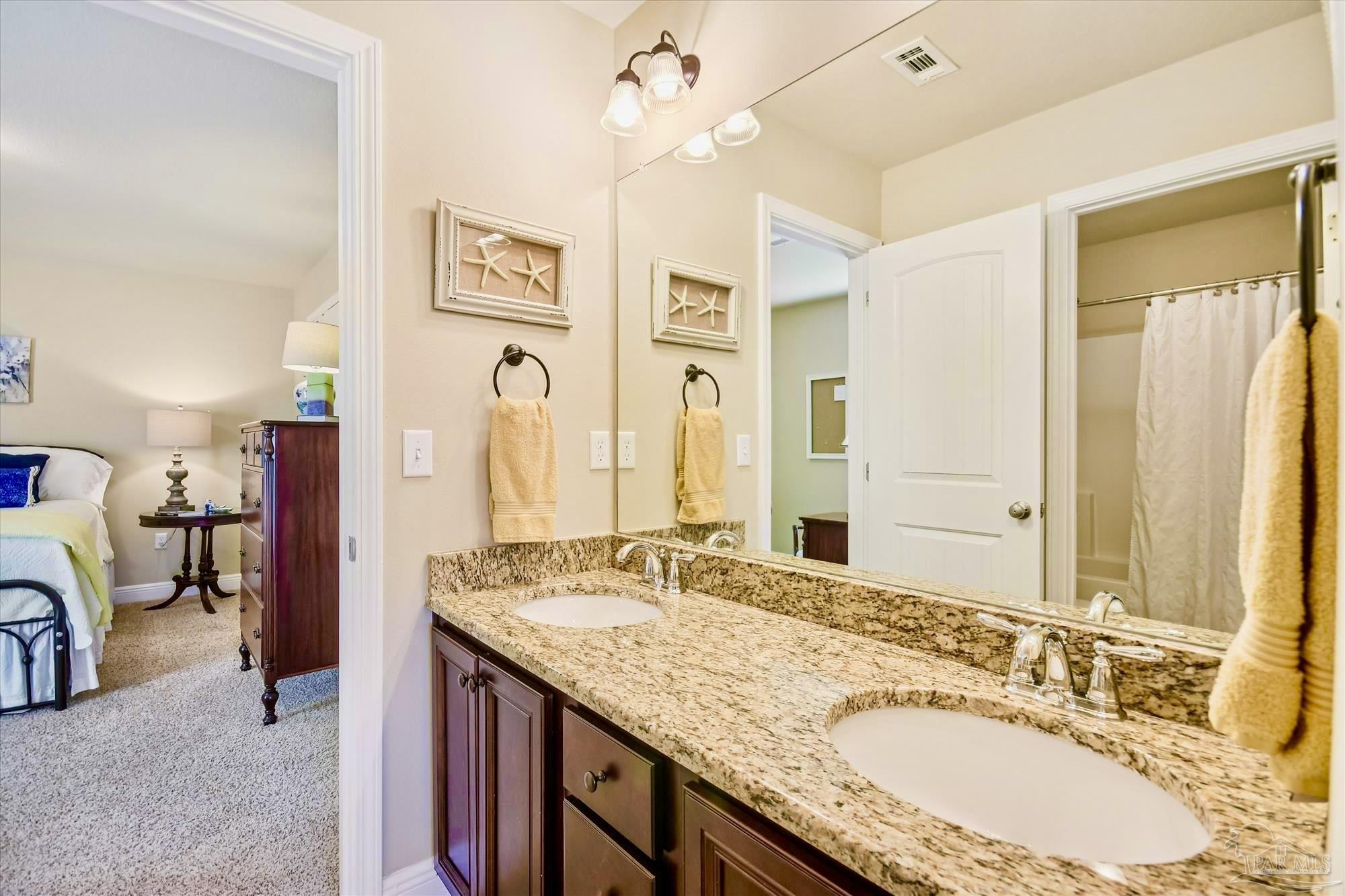 745 Farmington Road Pensacola, FL 32504 - Photo 21 of 25 a bathroom with a granite countertop double vanity sink and a mirror