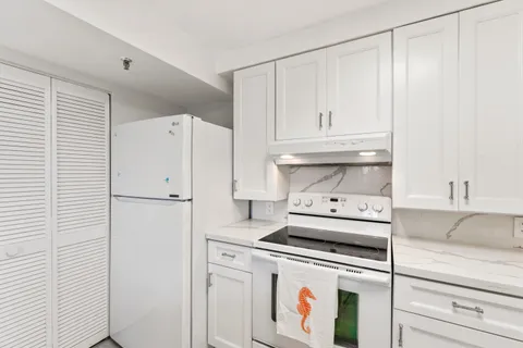 a kitchen with a white cabinets and white appliances