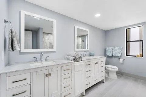 a bathroom with double sink and a toilet