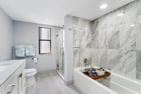 a bathroom with a sink a toilet and shower