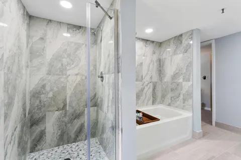 a bathroom with a tub a shower and a sink