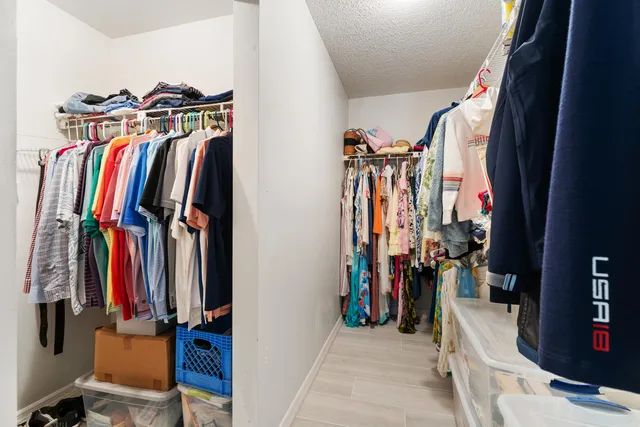a view of walk in closet with clothes