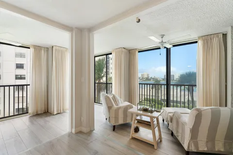 a living room with furniture and two large window or couch