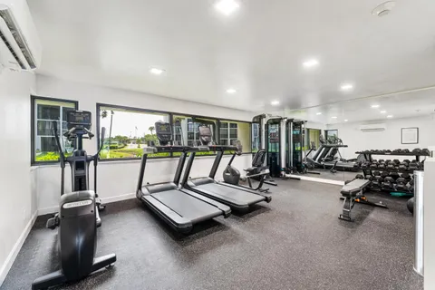 a living room with furniture gym equipment and a large window