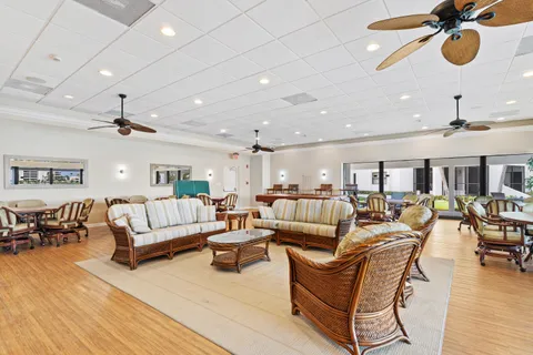 a living room with furniture kitchen view and a wooden floor