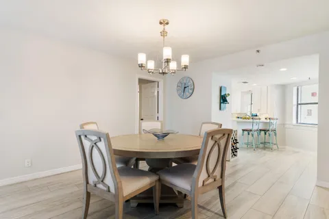 a view of a dining room with furniture a chandelier and wooden floor