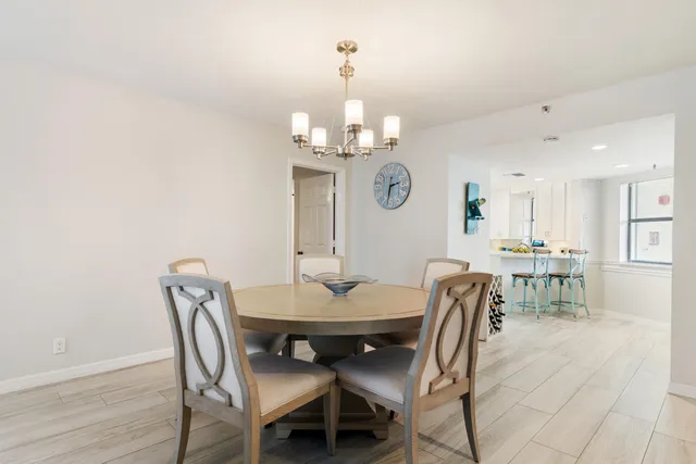 a view of a dining room with furniture a chandelier and wooden floor