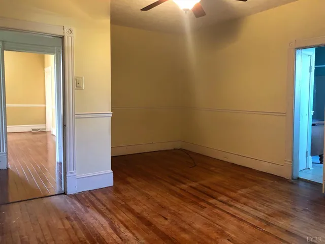 an empty room with wooden floor and door