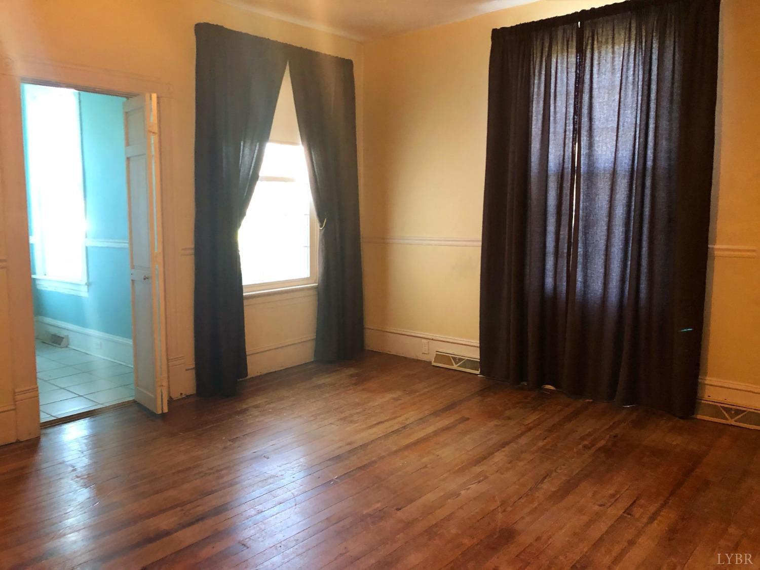 501 Jeter Street Bedford, VA 24523 - Photo 10 of 15 an empty room with wooden floor and windows