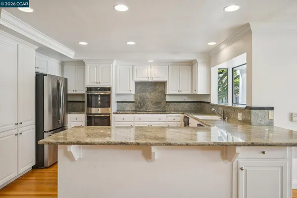 a kitchen with granite countertop white cabinets and white appliances