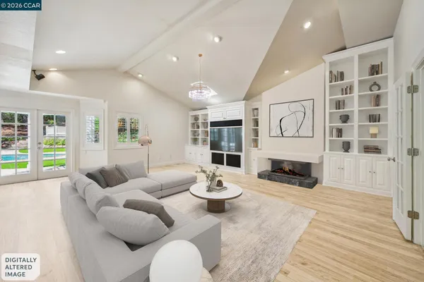 an empty room with wooden floor fireplace and windows