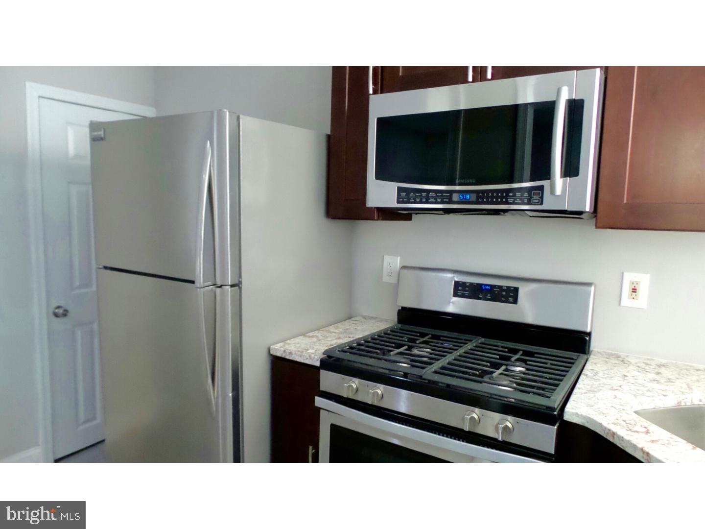1640 South 28th Street Philadelphia, PA 19145 - Photo 8 of 24 a kitchen with stainless steel appliances kitchen island a stove and a microwave