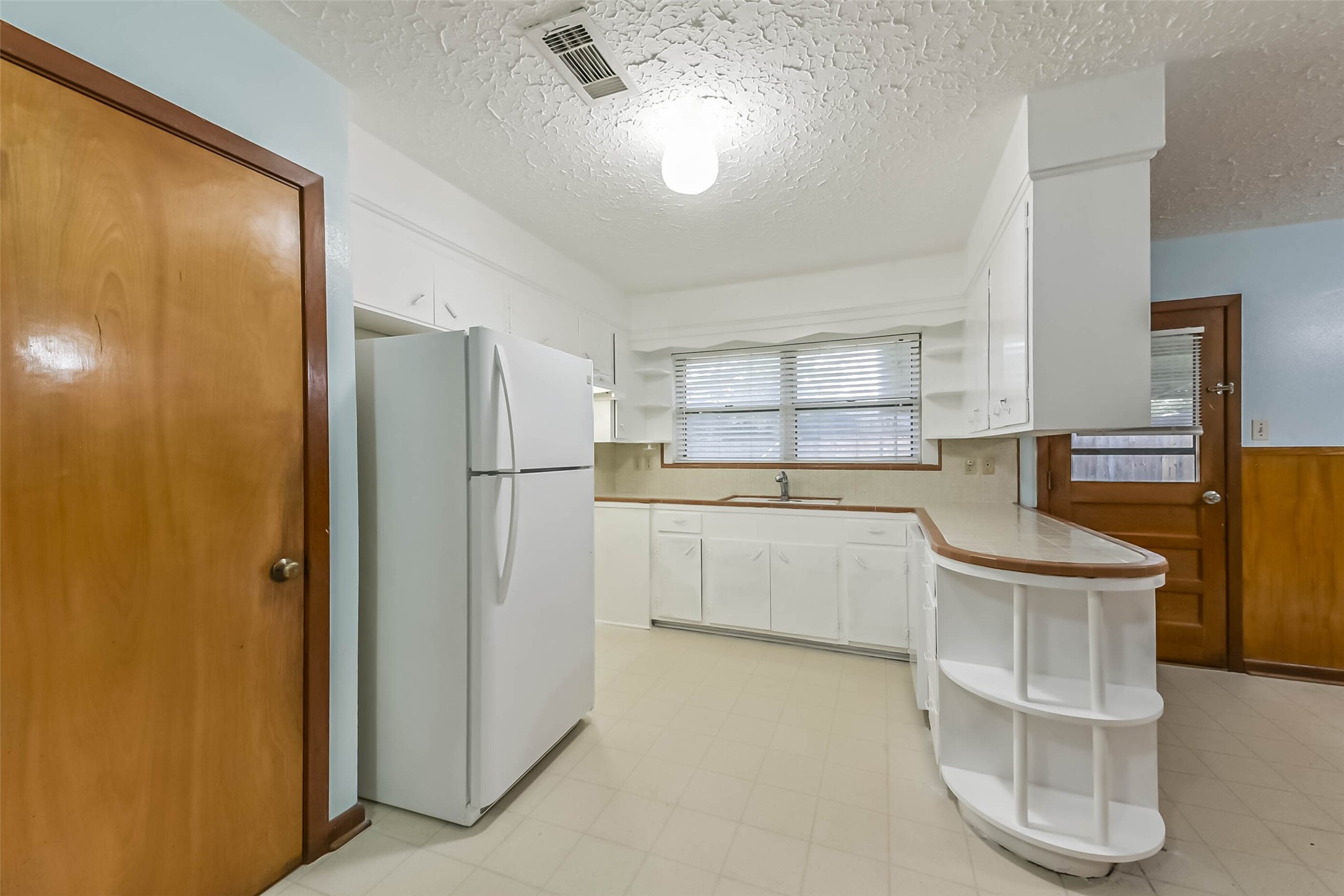 705 Dunwick Lane Pasadena, TX 77502 - Photo 6 of 27 a kitchen with white cabinets and refrigerator