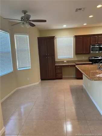a large kitchen with kitchen island granite countertop a sink and a stove top oven a granite counter tops