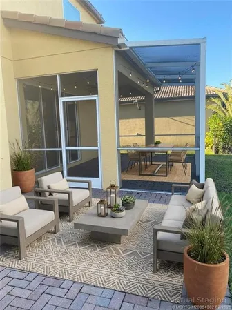 a living room with patio furniture and a potted plant