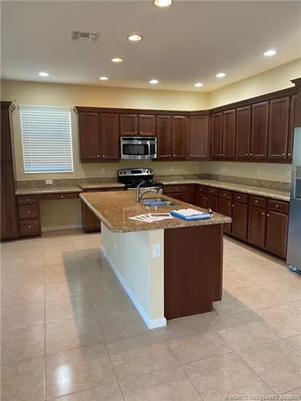 a kitchen with stainless steel appliances granite countertop a stove a sink and a refrigerator