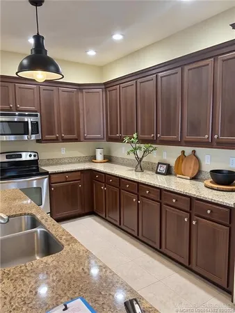 a kitchen with granite countertop a sink stainless steel appliances and cabinets