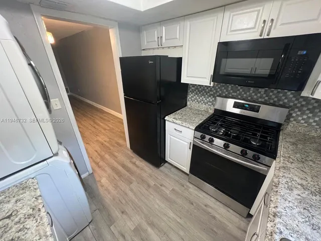 a kitchen with stainless steel appliances a stove a microwave and a refrigerator