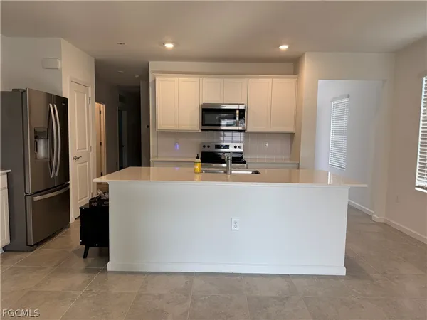 a kitchen with stainless steel appliances a refrigerator a stove a microwave and a refrigerator