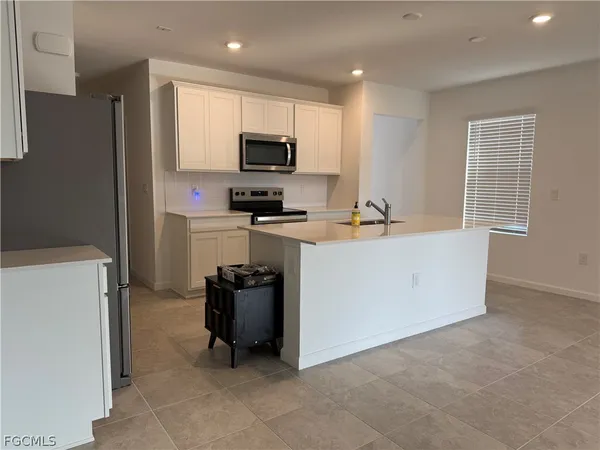 a view of kitchen with cabinets and refrigerator