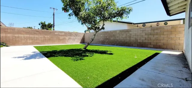 a white house with a small yard and a large parking space