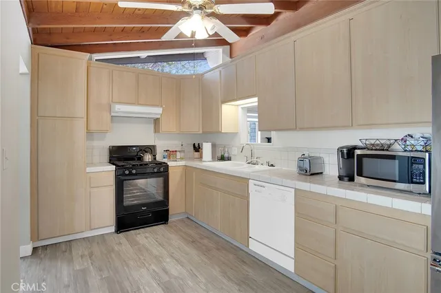 a kitchen with granite countertop white cabinets and stainless steel appliances